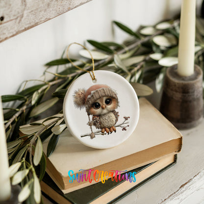 winter owl perched on a snowy branch ceramic Christmas ornament styled on stacked books with greenery