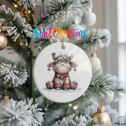 Highland cow in a pink scarf with winter flowers ceramic Christmas ornament hanging on a frosted Christmas tree