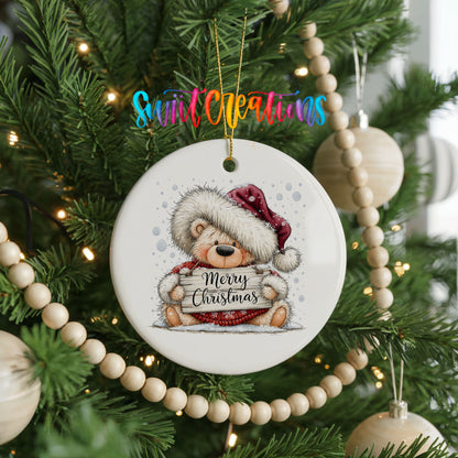 teddy bear holding a Merry Christmas sign ceramic Christmas ornament hanging on a green Christmas tree