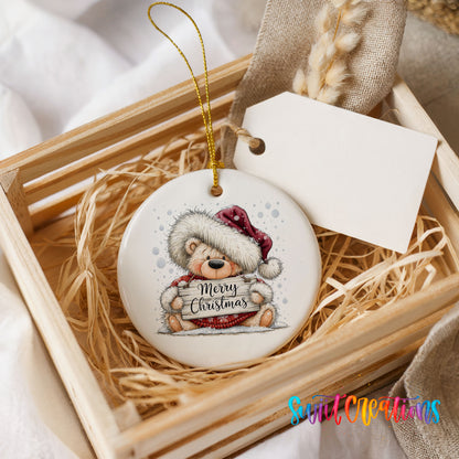 teddy bear holding a Merry Christmas sign ceramic Christmas ornament displayed in a wooden gift crate