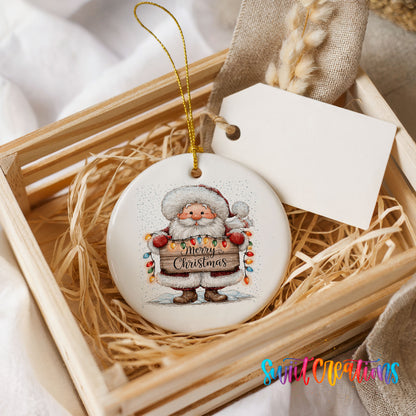 Santa Claus holding a Merry Christmas sign with Christmas lights ceramic Christmas ornament displayed in a wooden gift crate