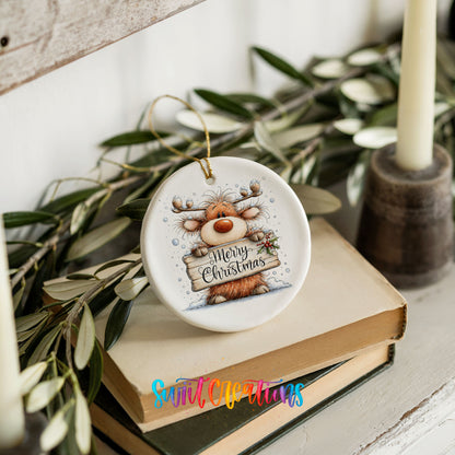 reindeer holding a Merry Christmas sign ceramic Christmas ornament styled on stacked books with greenery