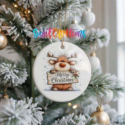 reindeer holding a Merry Christmas sign ceramic Christmas ornament hanging on a frosted Christmas tree