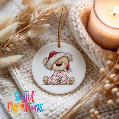 teddy bear in a Santa hat and pink polka dot scarf ceramic Christmas ornament styled on a cozy knit blanket