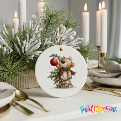 teddy bear holding a red ornament beside a Christmas tree ceramic Christmas ornament shown in a holiday table setting