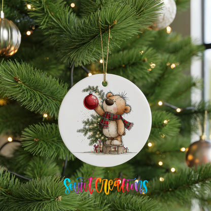 teddy bear holding a red ornament beside a Christmas tree ceramic Christmas ornament hanging on a lit Christmas tree