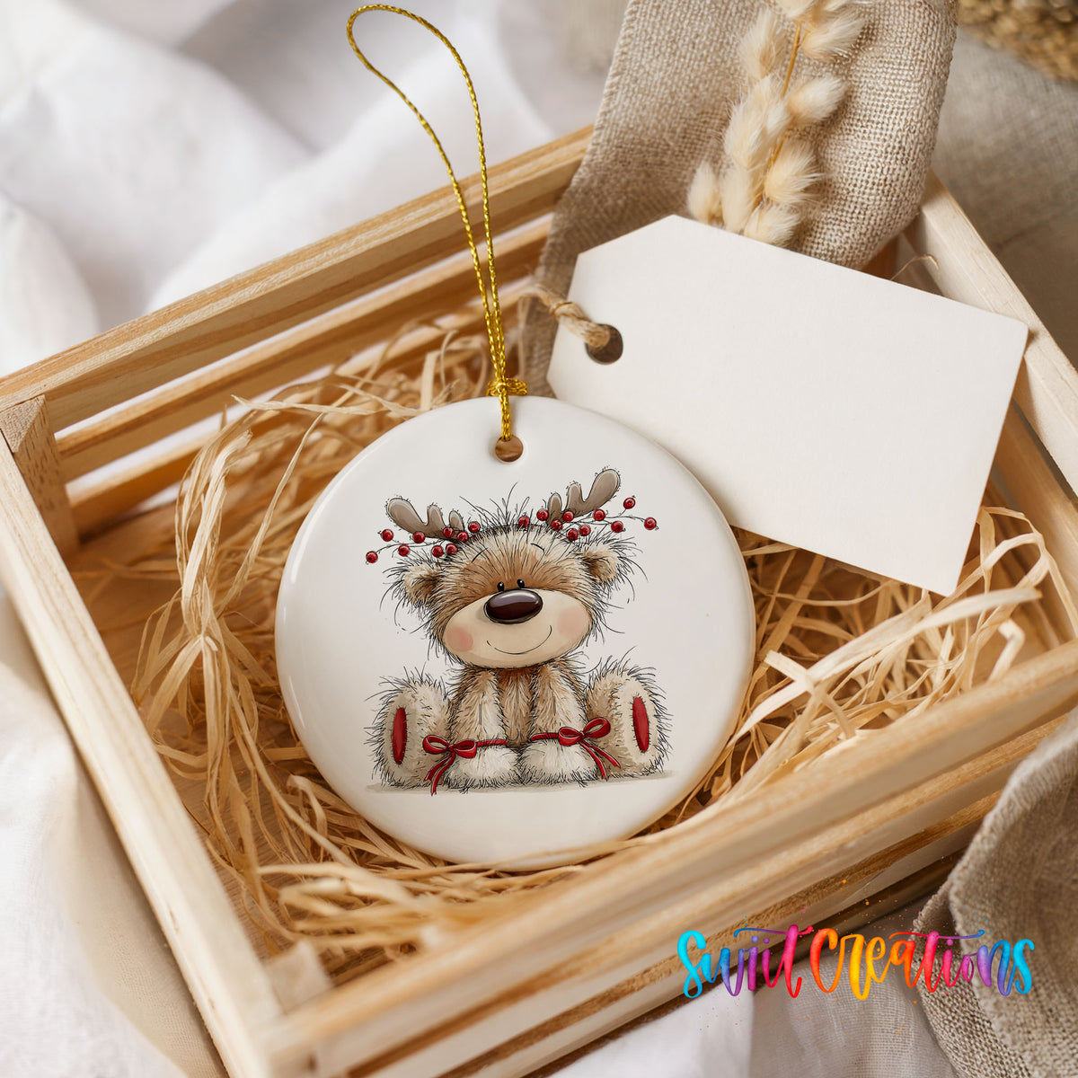 teddy bear wearing reindeer antlers with red winter skis ceramic Christmas ornament displayed in a wooden gift crate