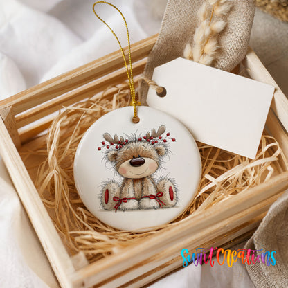teddy bear wearing reindeer antlers with red winter skis ceramic Christmas ornament displayed in a wooden gift crate