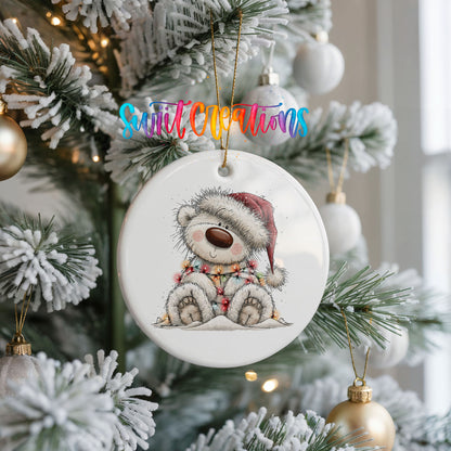 polar bear in a Santa hat and striped scarf ceramic Christmas ornament hanging on a frosted Christmas tree