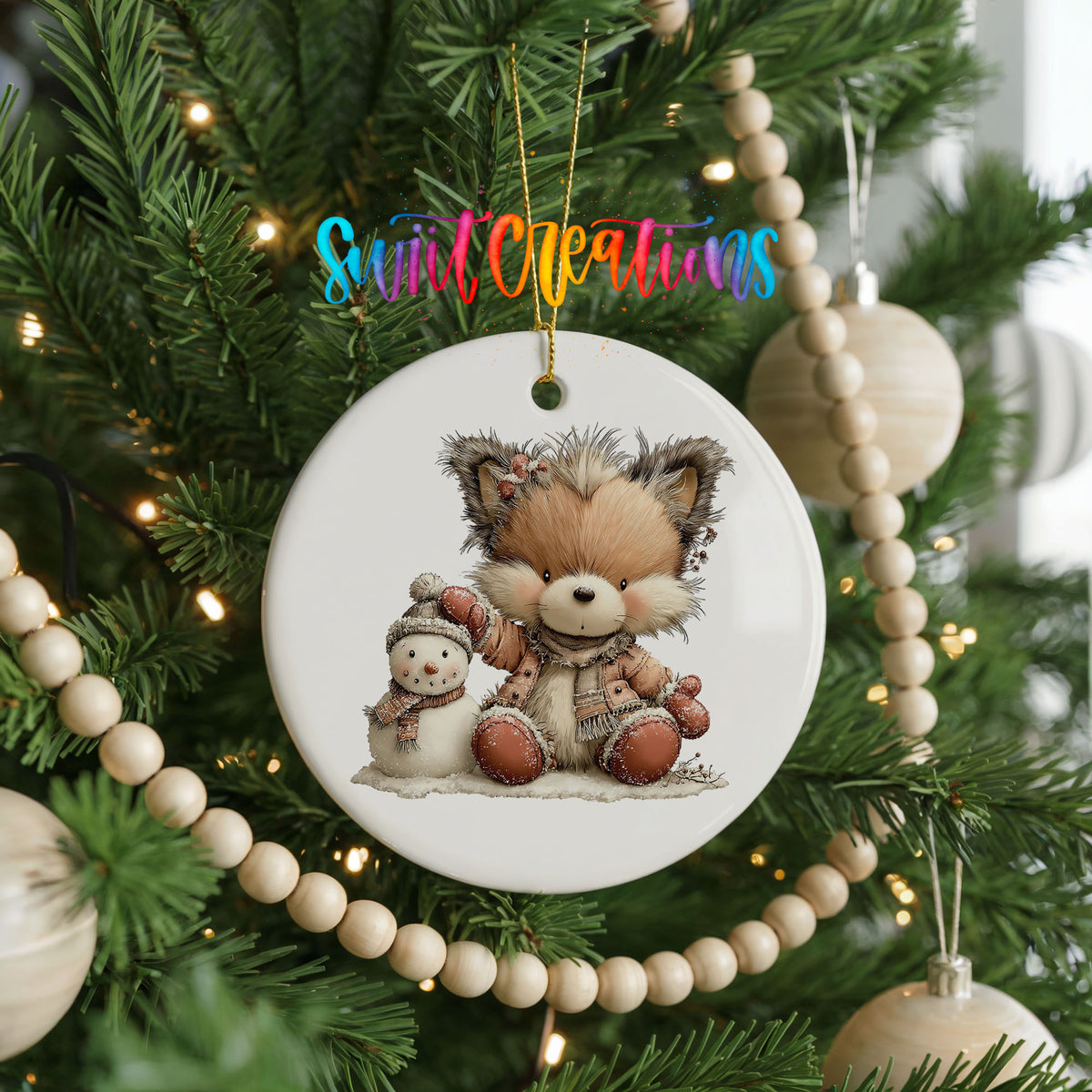 winter fox cuddling a small snowman ceramic Christmas ornament hanging on a green Christmas tree