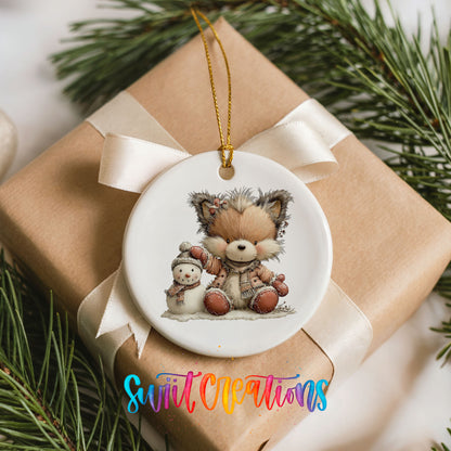 winter fox cuddling a small snowman ceramic Christmas ornament displayed on a wrapped Christmas gift