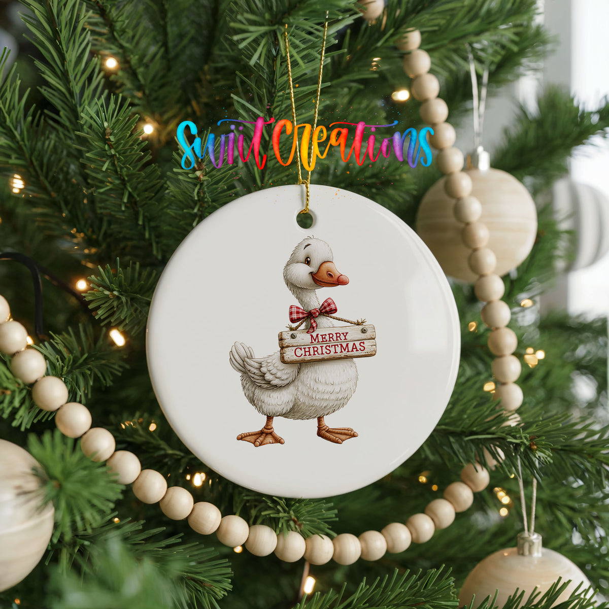 Christmas goose holding a Merry Christmas sign ceramic Christmas ornament hanging on a green Christmas tree