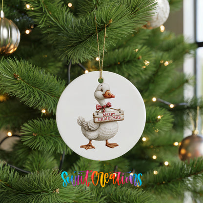 Christmas goose holding a Merry Christmas sign ceramic Christmas ornament hanging on a lit Christmas tree