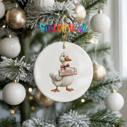 Christmas goose holding a Merry Christmas sign ceramic Christmas ornament hanging on a frosted tree with ornaments