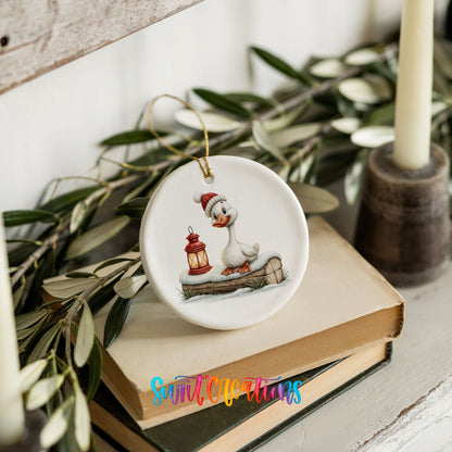 Christmas goose standing beside a red lantern ceramic Christmas ornament styled on stacked books with greenery