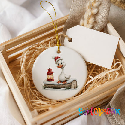 Christmas goose standing beside a red lantern ceramic Christmas ornament displayed in a wooden gift crate