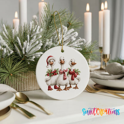 three Christmas geese wearing holiday wreaths ceramic Christmas ornament shown in a holiday table setting