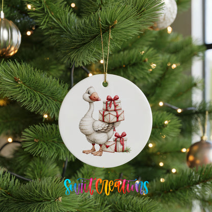 Christmas goose carrying a stack of wrapped gifts ceramic Christmas ornament hanging on a lit Christmas tree