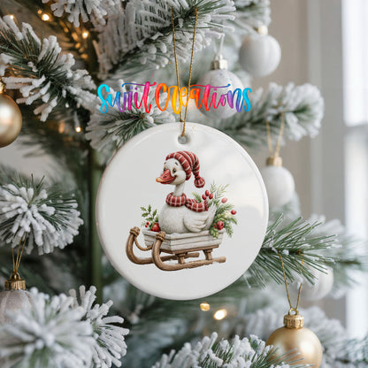 Christmas goose riding on a wooden sled ceramic Christmas ornament hanging on a frosted Christmas tree