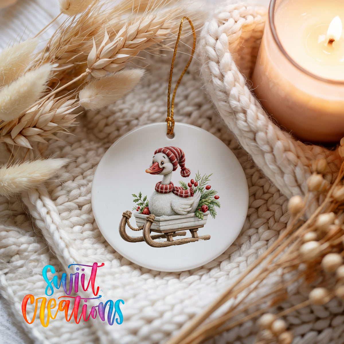 Christmas goose riding on a wooden sled ceramic Christmas ornament styled on a cozy knit blanket