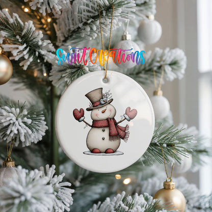 snowman in a top hat with red heart mittens ceramic Christmas ornament hanging on a frosted Christmas tree