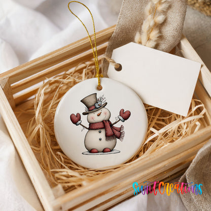 snowman in a top hat with red heart mittens ceramic Christmas ornament displayed in a wooden gift crate