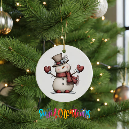 snowman in a top hat with red heart mittens ceramic Christmas ornament hanging on a lit Christmas tree