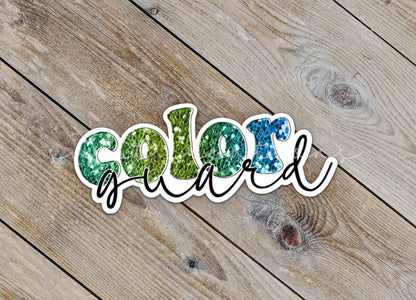 Close-up of the Green Glitter Color Guard sticker on rustic wood
