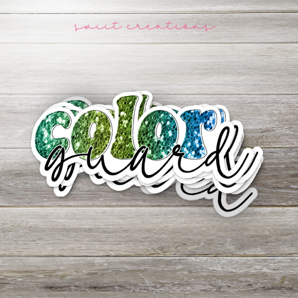 Stack of Green Glitter Color Guard glossy stickers on a gray wood table