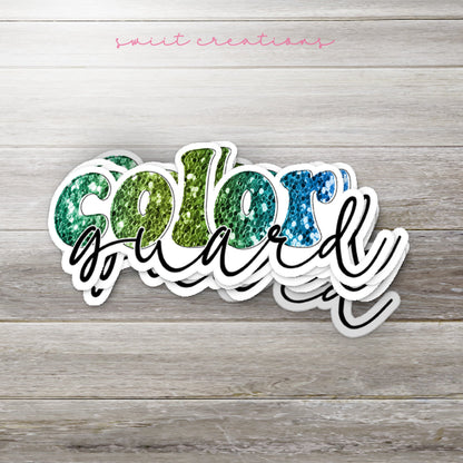 Stack of Green Glitter Color Guard glossy stickers on a gray wood table