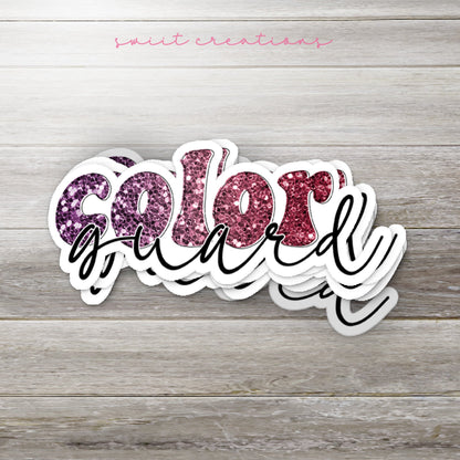 Stack of Maroon Glitter Color Guard glossy stickers on a gray wood table