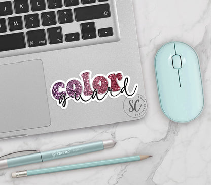 Maroon Glitter Color Guard vinyl sticker on a silver laptop next to a mint mouse and pens