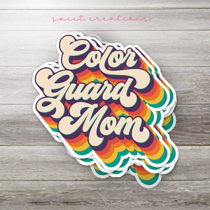 Stack of Retro Color Guard Mom glossy stickers on a gray wood table