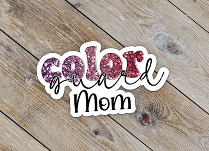 Close-up of the Maroon Glitter Color Guard Mom sticker on rustic wood