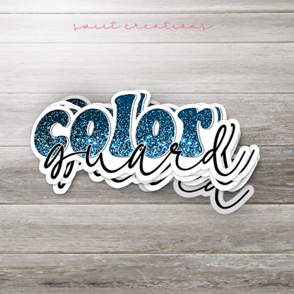Stack of Blue Glitter Color Guard glossy stickers on a gray wood table