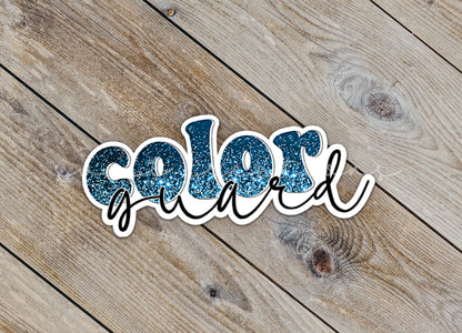 Close-up of the Blue Glitter Color Guard sticker on rustic wood