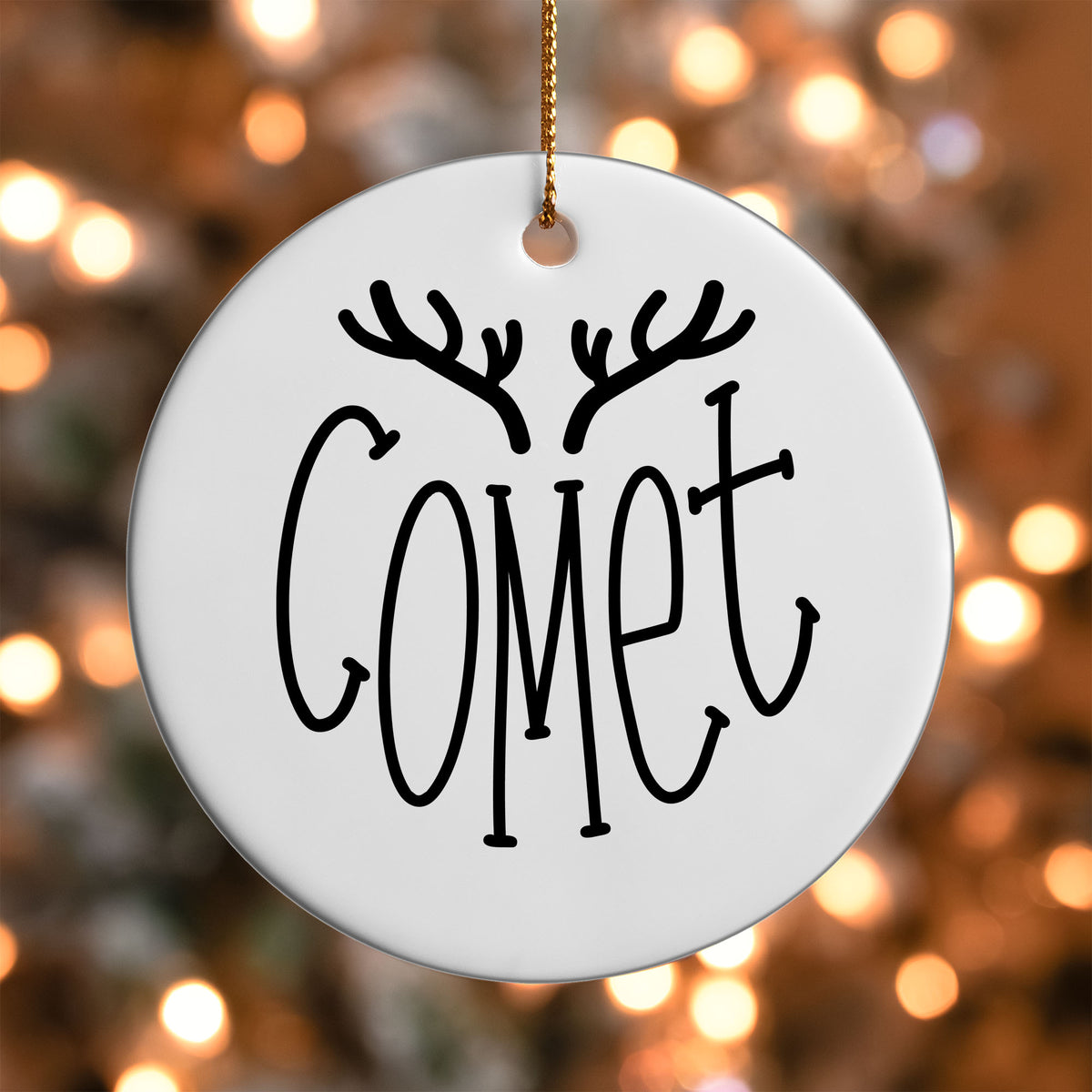 Comet Reindeer Name ornament UV DTF transfer on a round white ornament with a bokeh light background