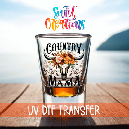 Country Mama shot glass UV DTF transfer on a filled shot glass on a dock by the water