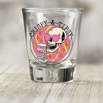 Crispy and Tipsy shot glass UV DTF transfer with skull in pink sunglasses with a pink cup on a clear shot glass