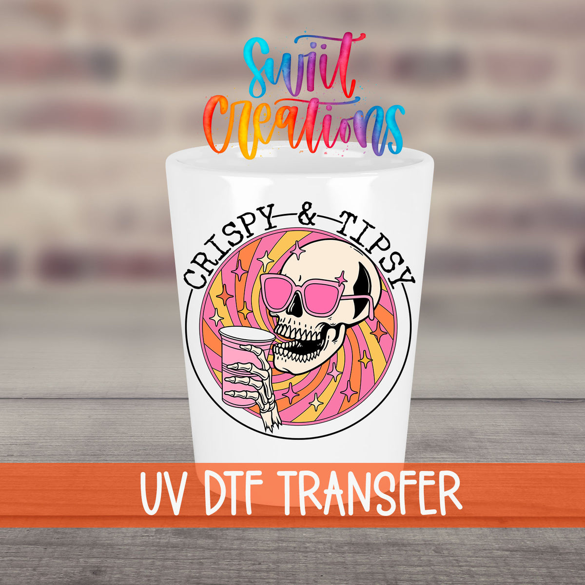 Crispy and Tipsy UV DTF transfer on a white shot glass in front of a brick wall
