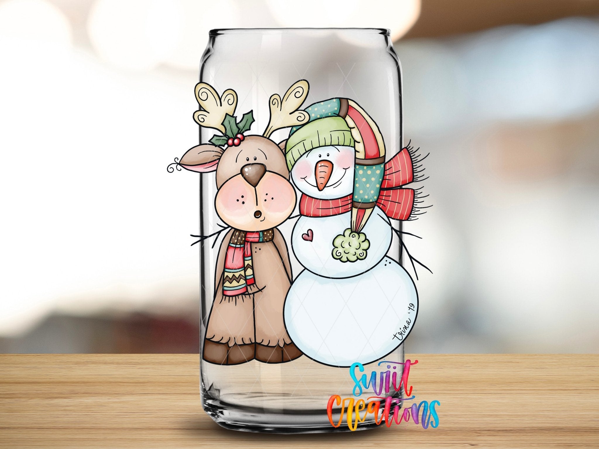 Swiit Creations cute reindeer and snowman UV DTF transfer shown on a clear glass can