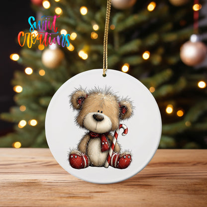 Teddy Bear with Candy Cane ornament UV DTF transfer on an ornament on a wooden table with tree lights behind it