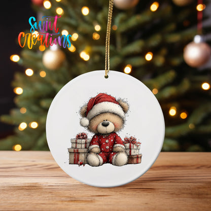Santa Teddy Bear with Gifts ornament UV DTF transfer on an ornament on a wooden table with tree lights behind it