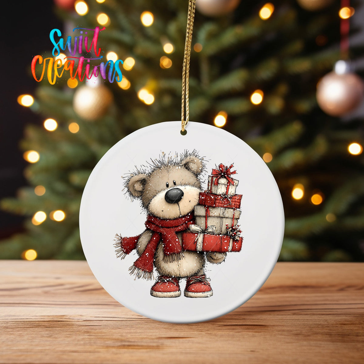 Teddy Bear with Presents ornament UV DTF transfer on an ornament on a wooden table with tree lights behind it