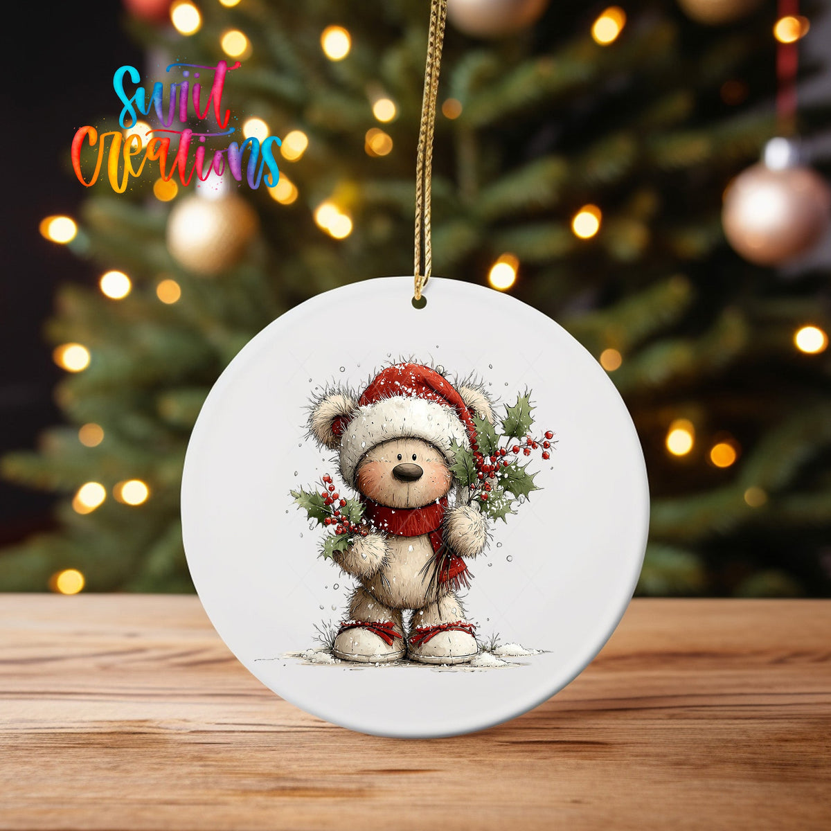 Teddy Bear in Santa Hat ornament UV DTF transfer on an ornament on a wooden table with tree lights behind it