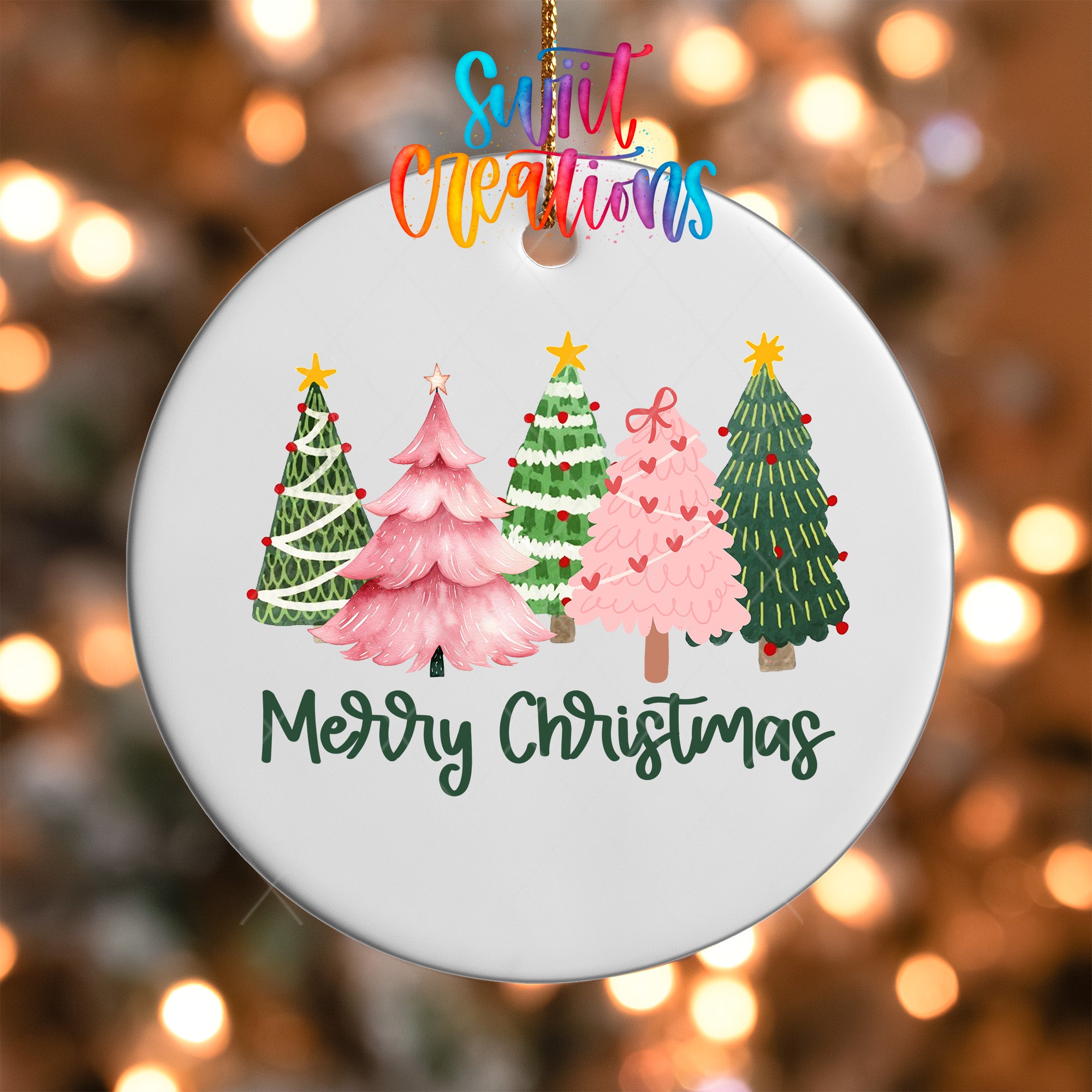 A white Christmas ornament with a festive design of four different colored Christmas trees, along with the text "Merry Christmas" written below them.