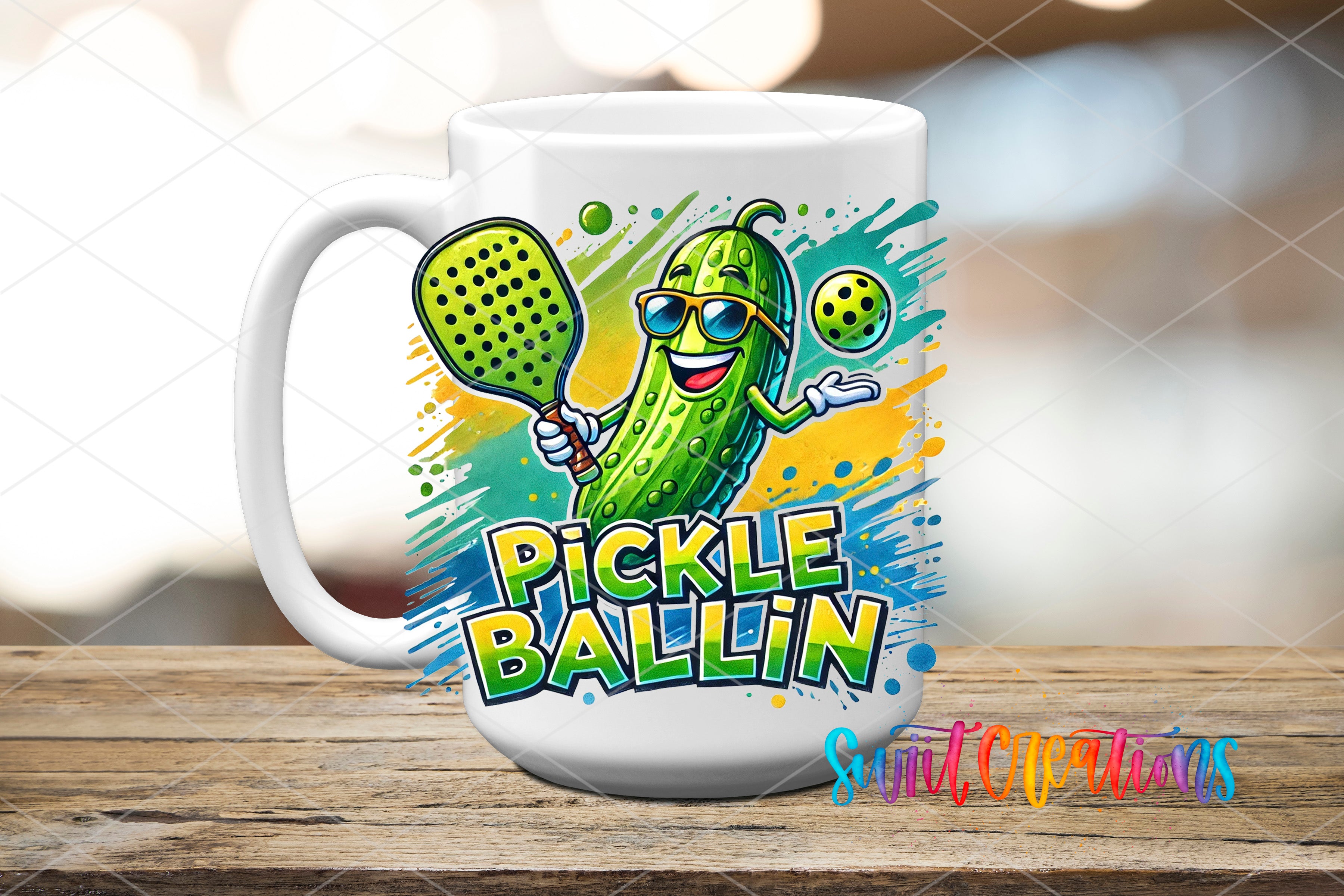 A white mug with a colorful illustration of a pickle wearing sunglasses and holding a tennis racket, with the text "Pickle Ballin" written on it.
