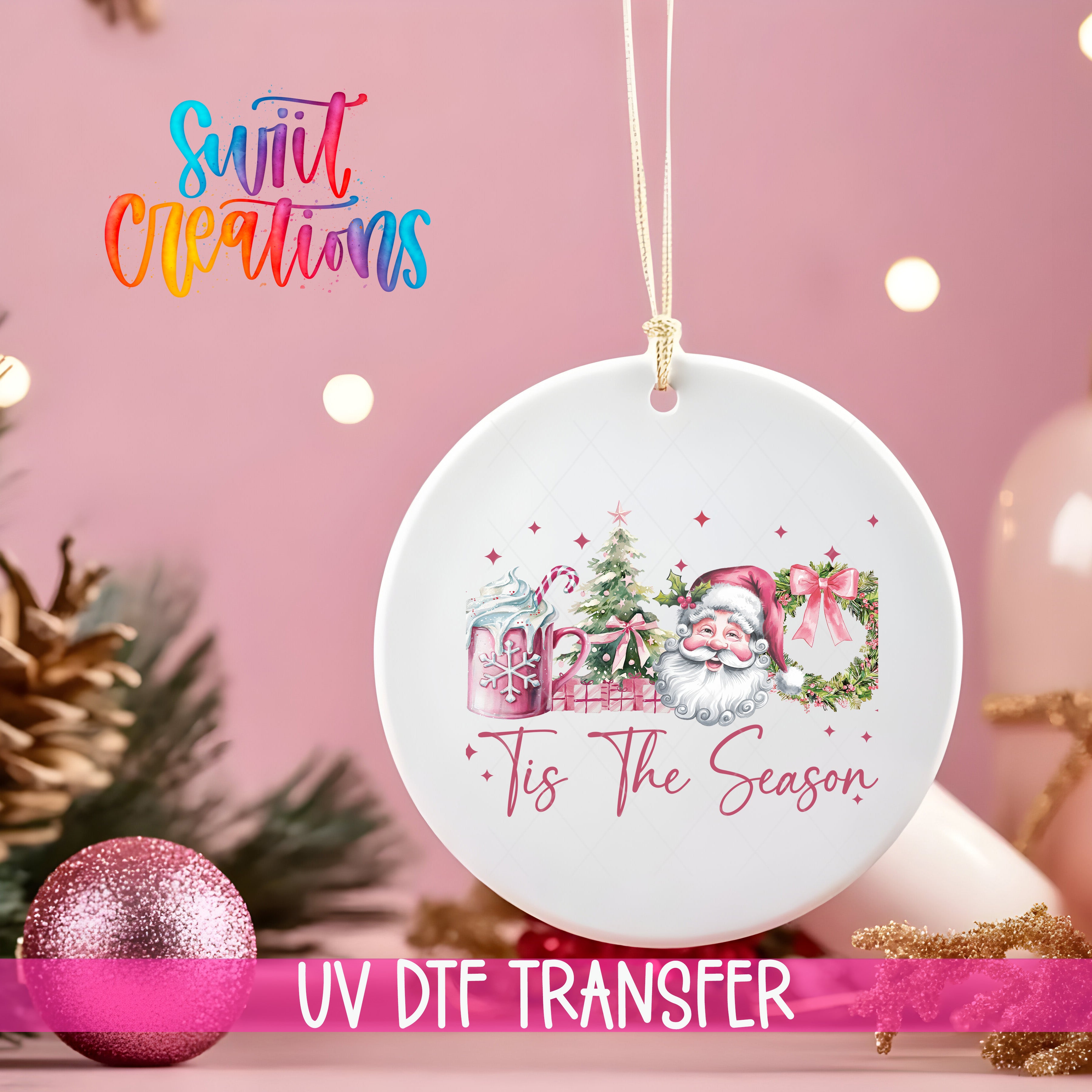 A white ornament with a Santa Claus design and the text "Tis the Season" hangs on a pink background, with a pink glitter ornament and Christmas tree decorations in the background.