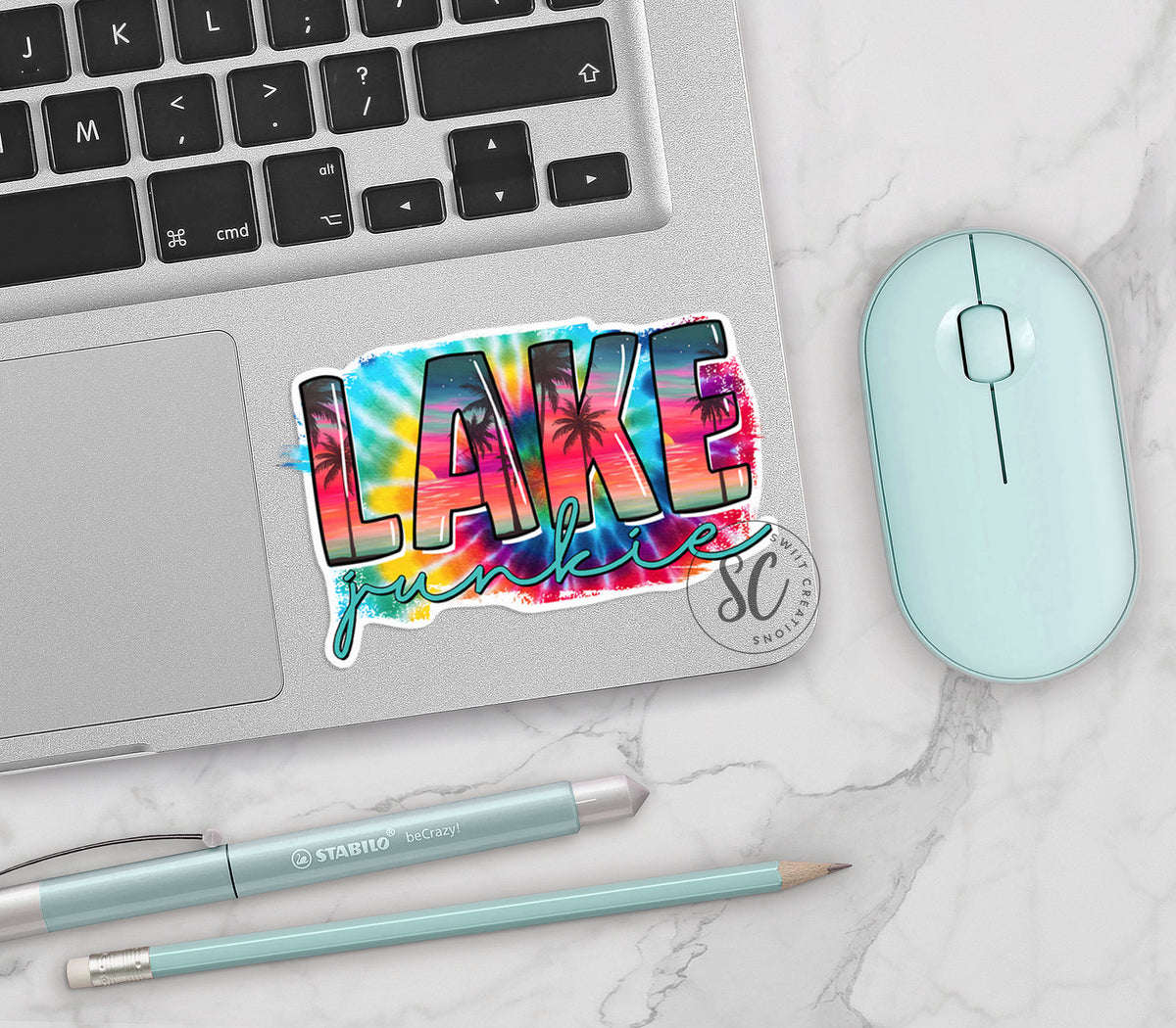 Lake Junkie vinyl sticker on a silver laptop next to a mint mouse and pens