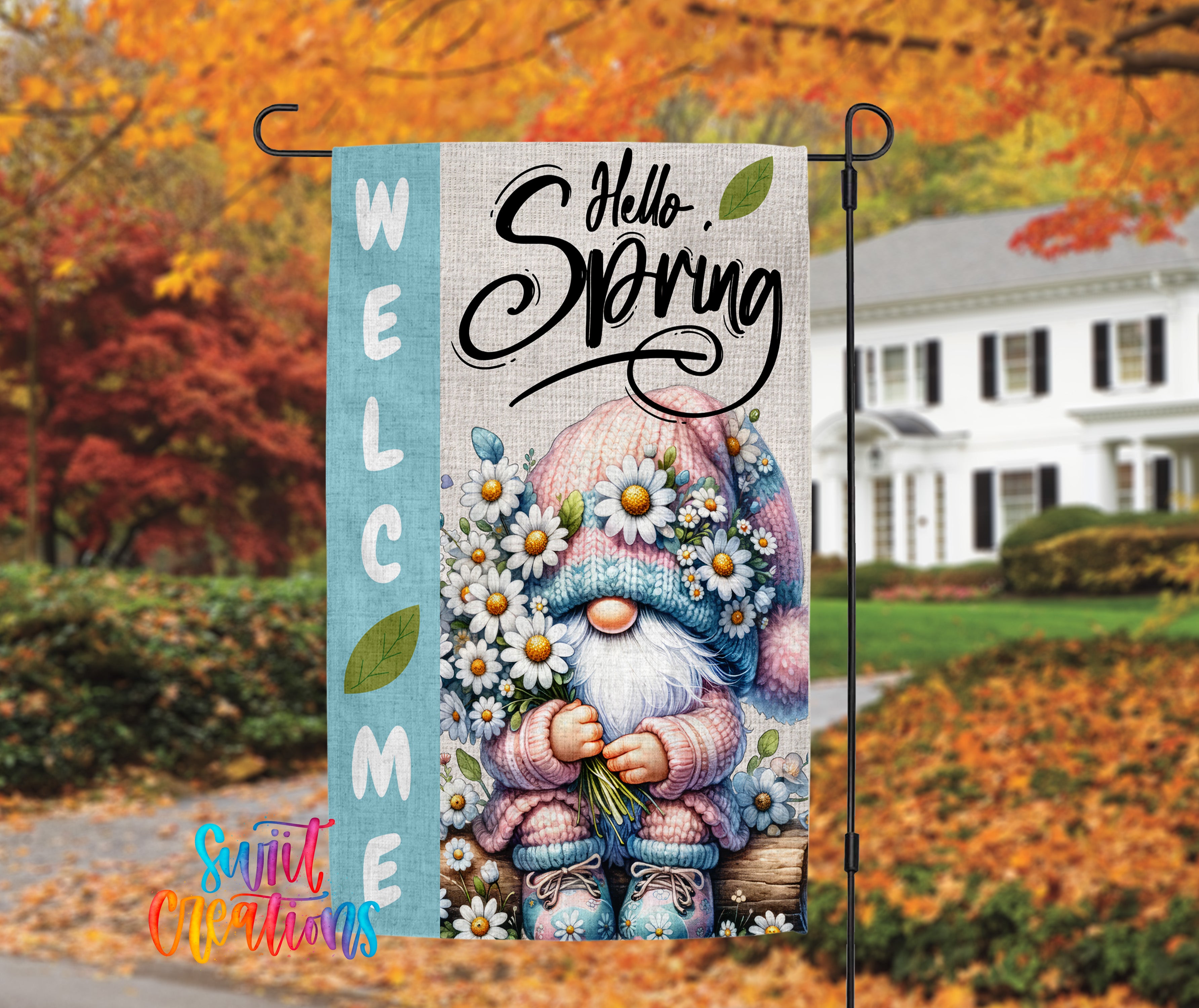 A colorful welcome sign featuring a gnome holding flowers, with a house and autumn foliage in the background.